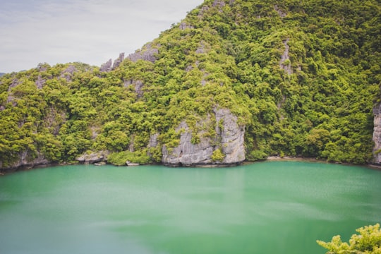 rock formation near green body of water water in Ang Thong Thailand