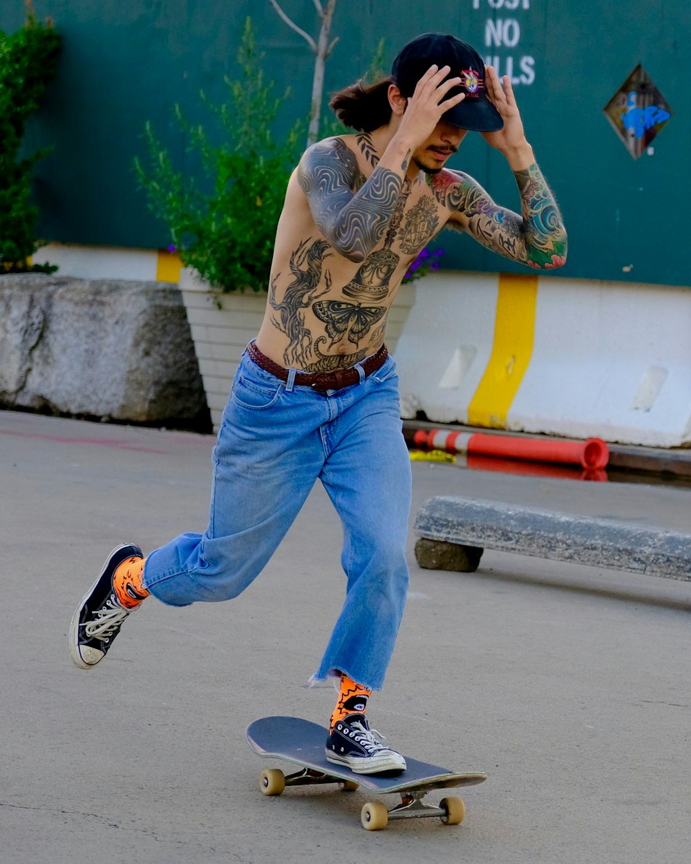 uomo che indossa blue jeans equitazione sullo skateboard