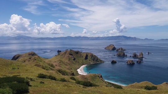 body of water near mountain during daytime in Kelapa Island Indonesia