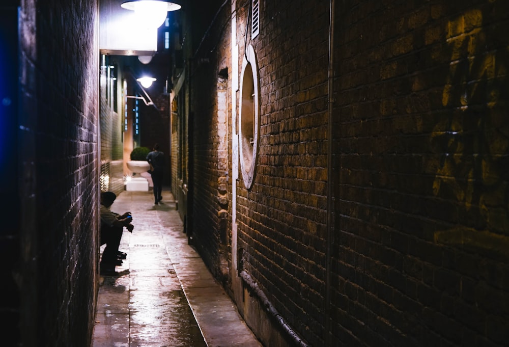 person sitting on road between buildings