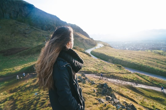 woman standing on hill in Arthur's Seat United Kingdom