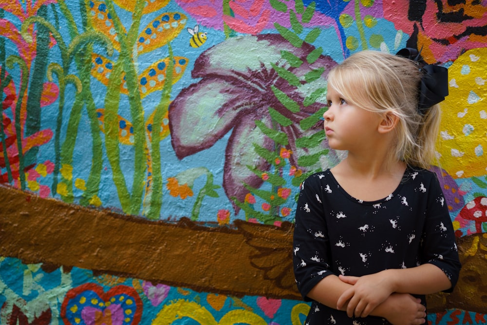 fille s’appuyant sur un mur floral