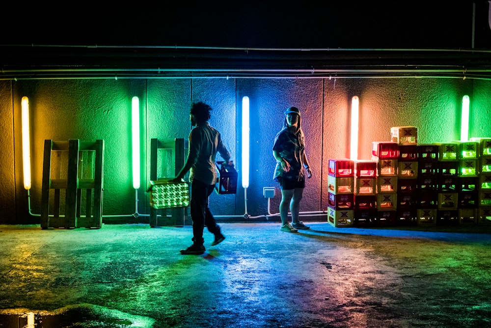two person standing near green and blue neon lights