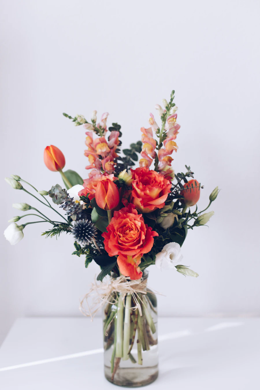 A vivid coral and orange bouquet against a dark background