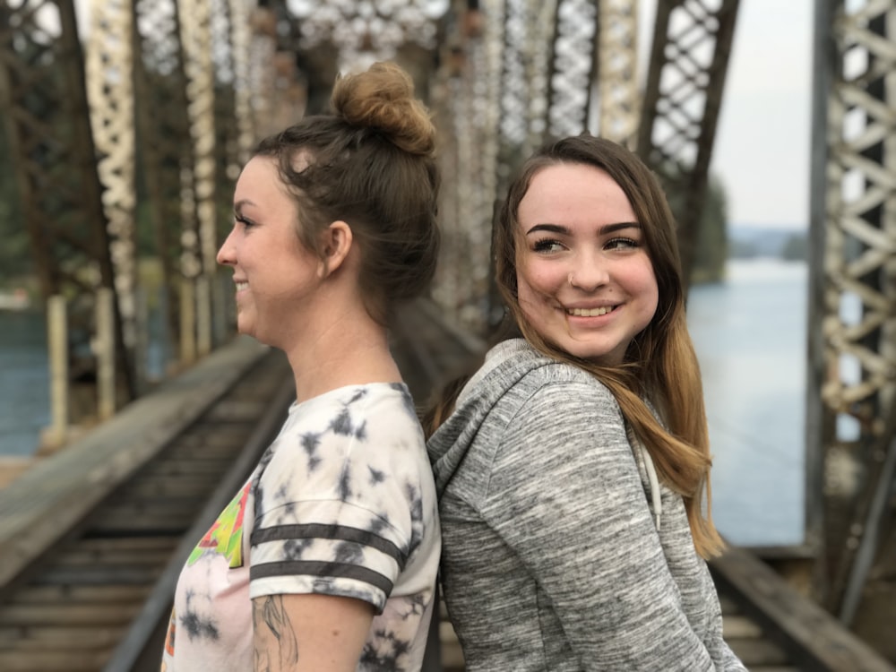 two women standing on bridge