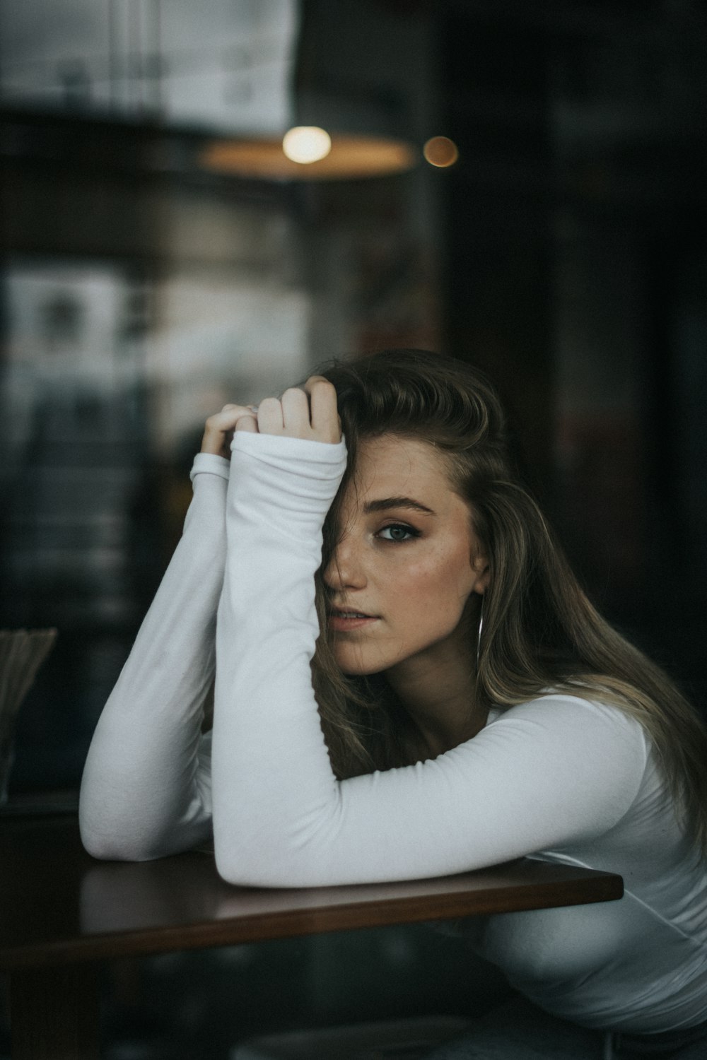 Photographie sélective de mise au point d’une femme se reposant les mains sur une table