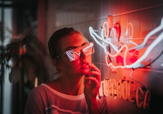 woman standing beside lighted neon lights