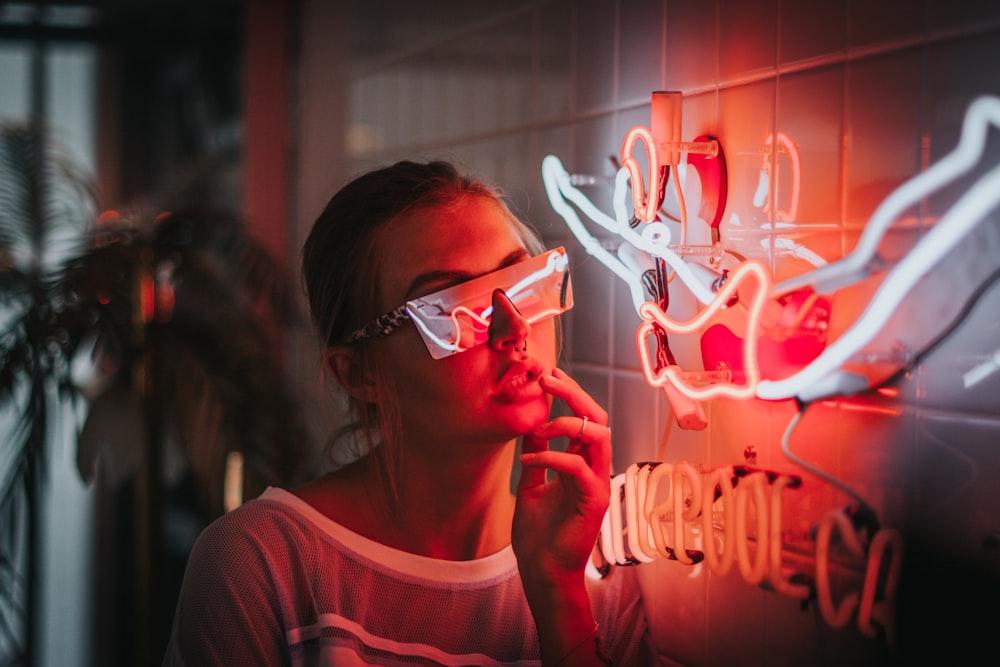 mujer de pie junto a luces de neón encendidas