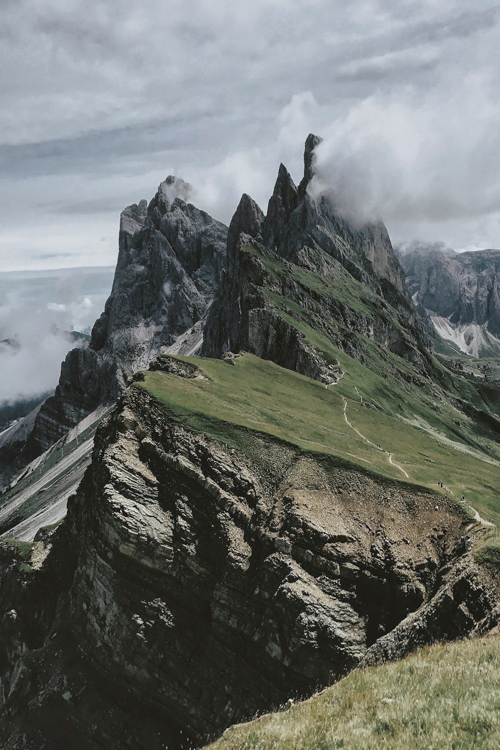 montagne rocciose verdi e grigie sotto nuvola bianca