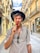 man wearing hat and grey shirt biting red candy on a stick
