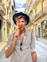 man wearing hat and grey shirt biting red candy on a stick