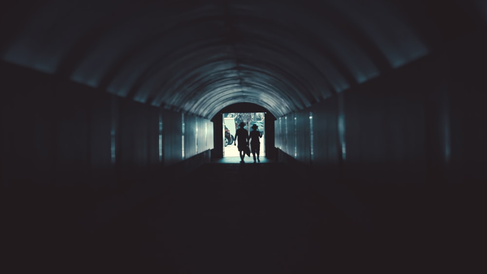 silhouette of man standing on tunnel