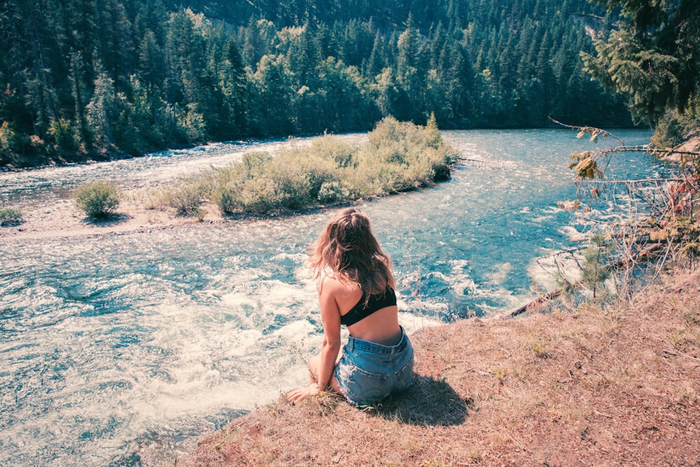 Femme portant un short en jean bleu regardant le plan d’eau