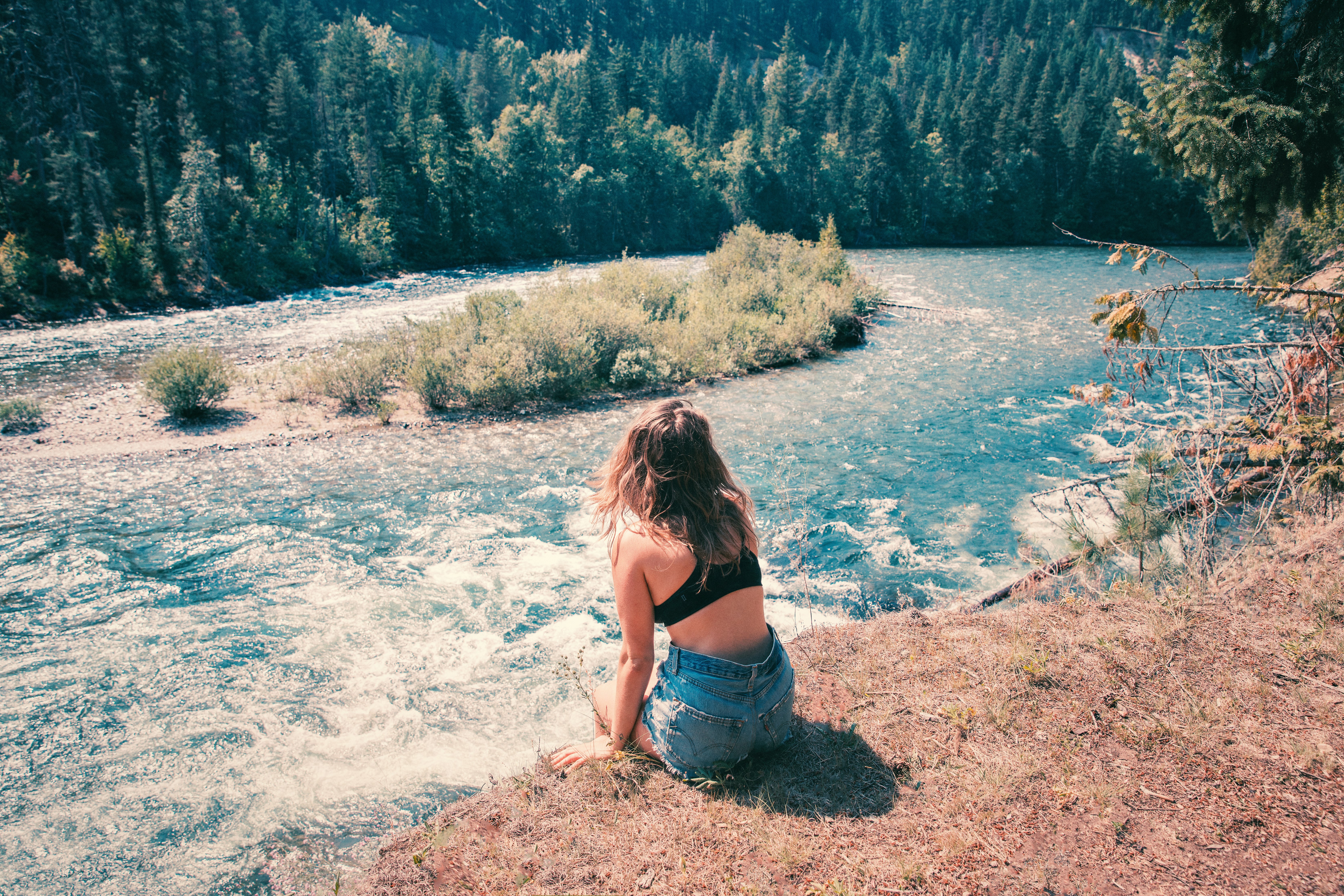 woman wearing blue denim shorts watching the body of water