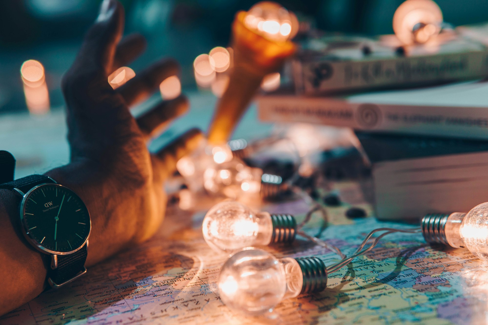 Lit lightbulbs and an open hand resting on a map