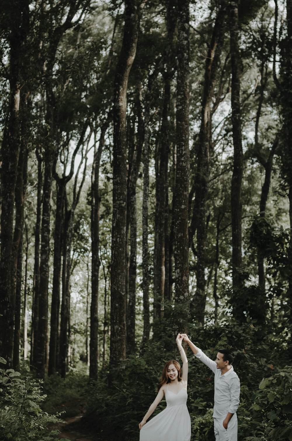 male and female dancing near tree