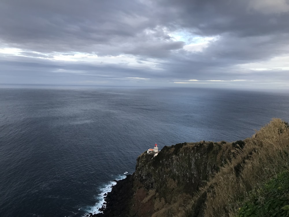 white lighthouse beside body of water