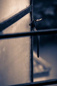 Close-up of a handyman fixing a window latch, ensuring it closes tightly against the frame.