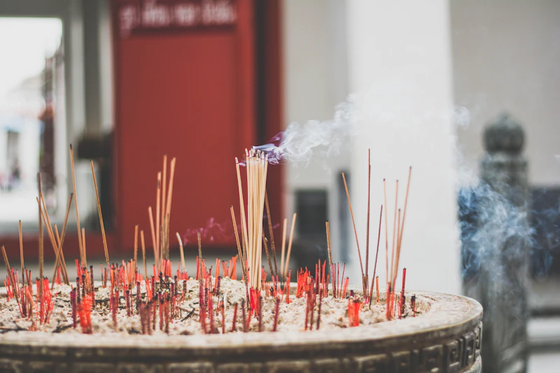 Incense smoke rising in a Bangkok temple courtyard