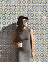 woman standing near the wall while holding beer bottle