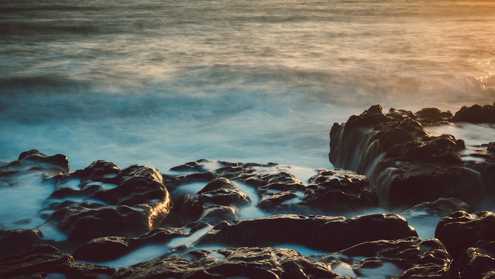 gray rock formations with sea waters at daytime