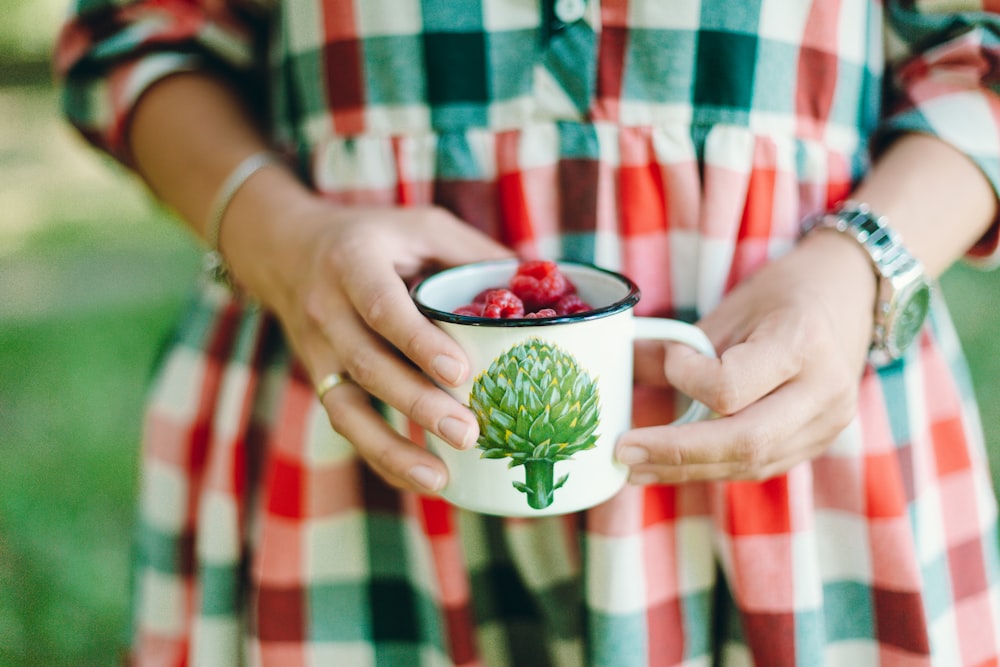 person holding cup of fruits