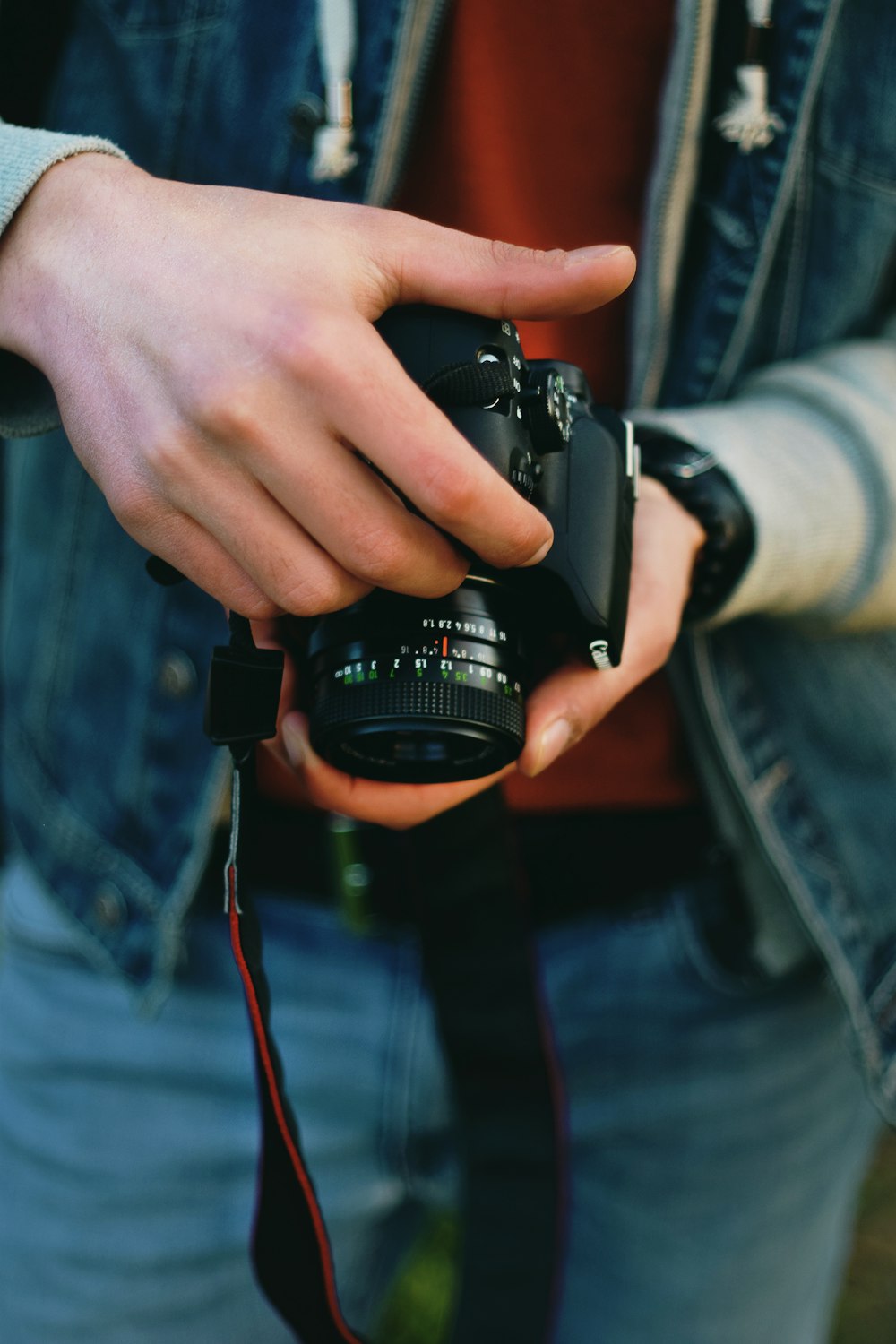persona sosteniendo una cámara Canon DSLR negra