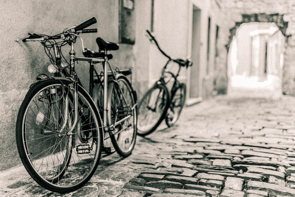 two bicycles leaning on alley way