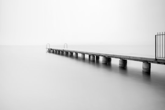 grayscale photo of concrete dock in Bardolino Italy