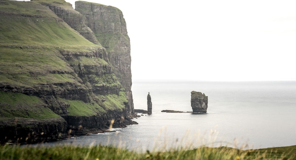 black boulder on body of water