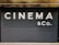 Large, bold white letters spell out 'CINEMA & CO.' on a black, corrugated metal shutter. The background appears industrial and slightly weathered, suggesting a closed or private cinema or entertainment venue.