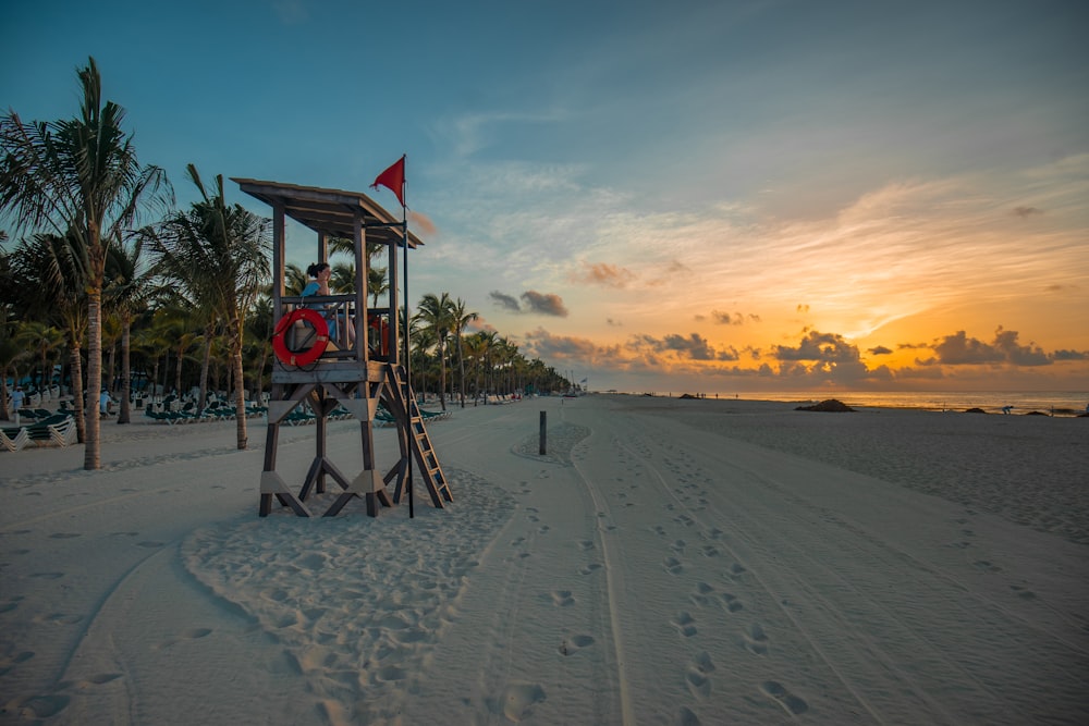 lifeguard sitting on lifeguard shed near seashore