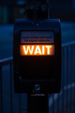 turned on black road signage displaying wait
