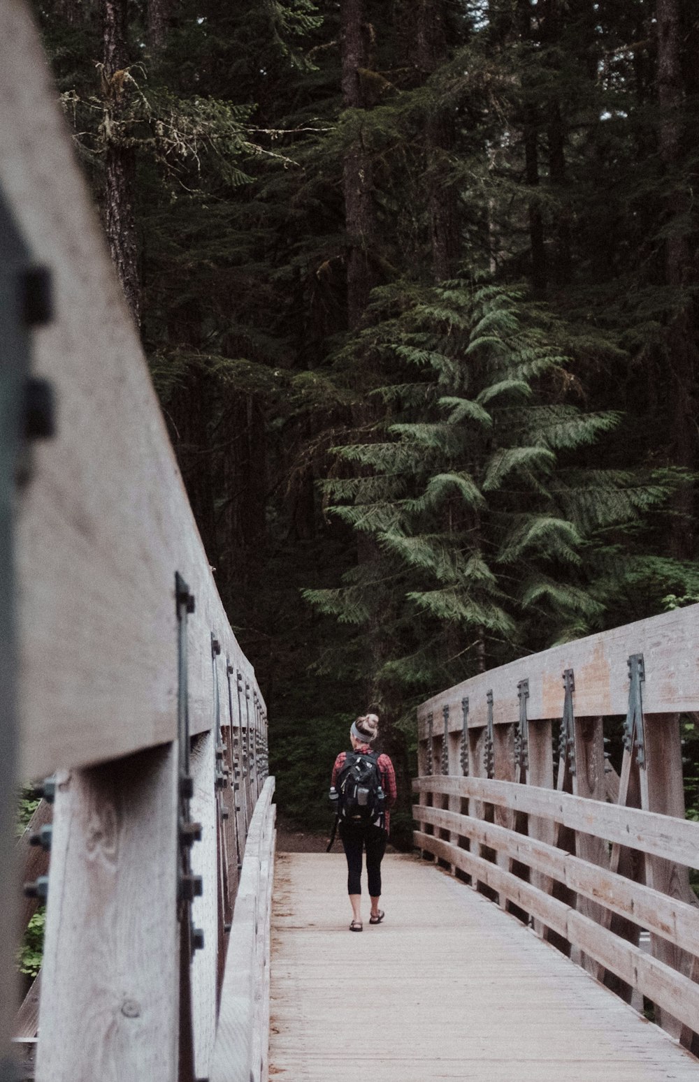 Femme marchant sur un pont en bois brun