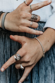 person wearing silver-colored and gold-colored rings
