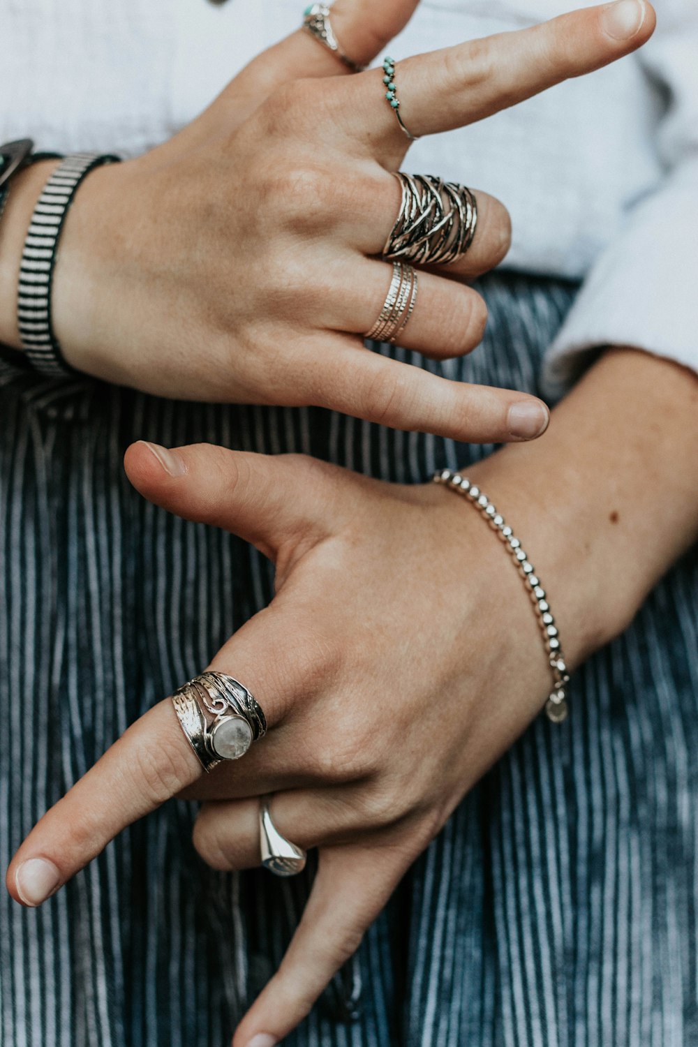 person wearing silver-colored and gold-colored rings