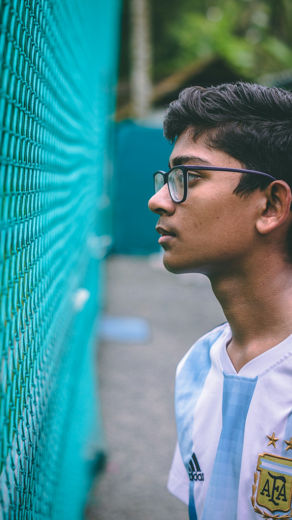 boy looking at teal fence