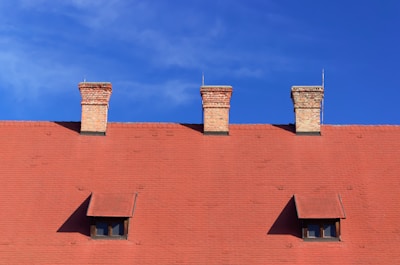 Roof with shingles and chimney under bright daylight.