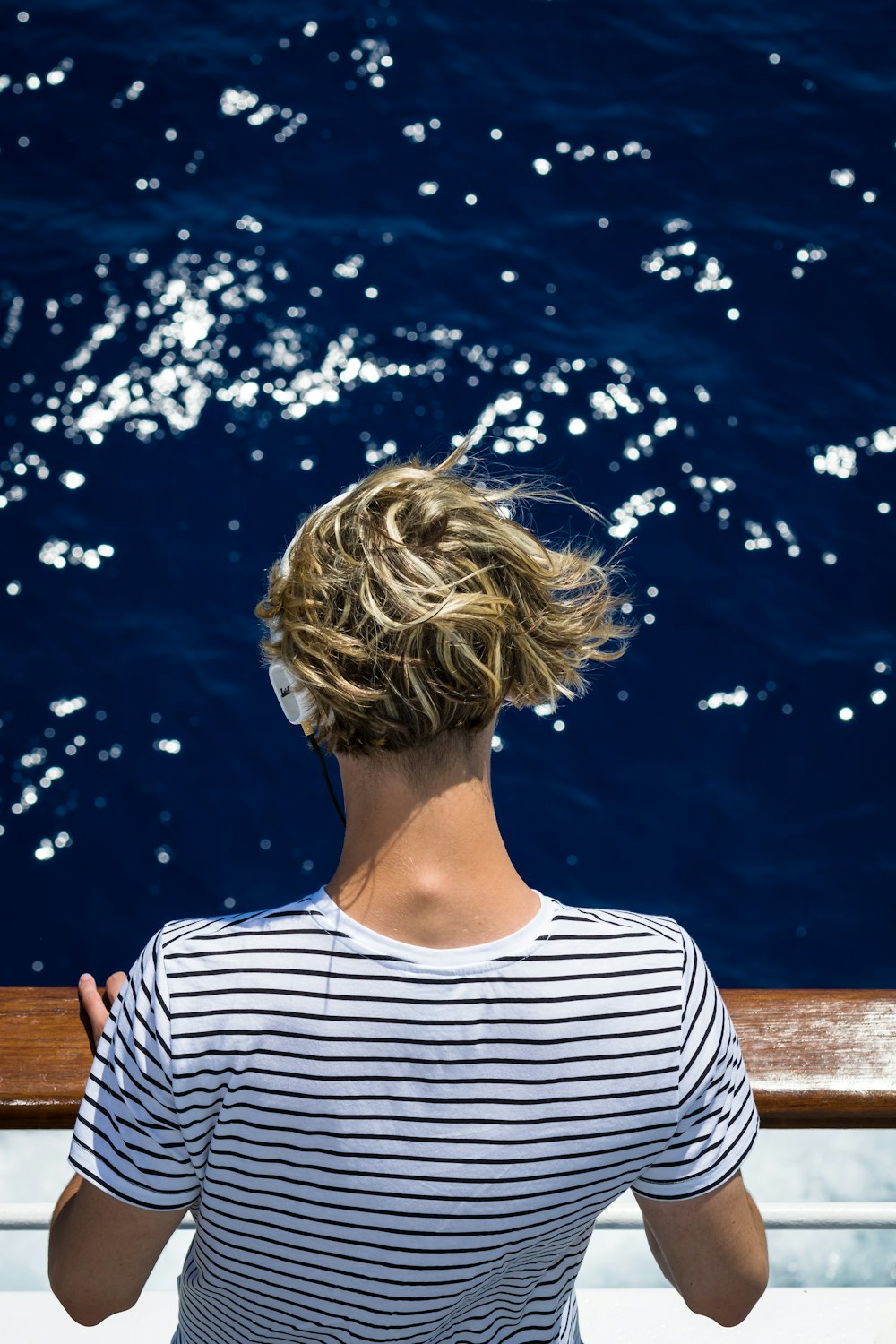 woman wearing white and black striped shirt looking at water