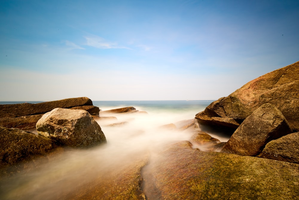 brown rock formation covered with smoke at daytime