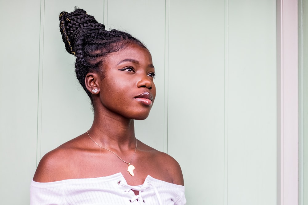 woman standing beside white wall