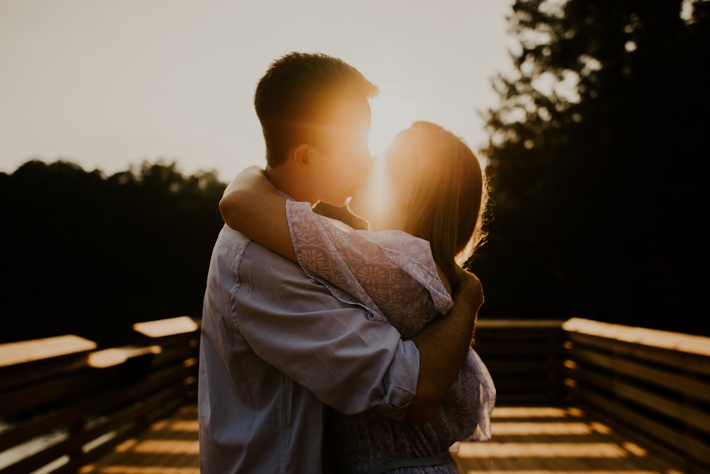 homem e mulher se beijando durante o pôr do sol