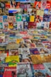 A collection of various book and magazine covers is arranged in a grid-like fashion. The covers feature multiple genres and styles, with illustrations, photographs, and text. The diverse assortment includes vibrant colors, artwork, and design elements, displaying a wide range of themes and cultural references.