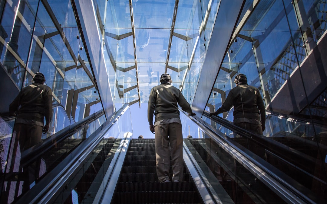 man standing on escalator during daytime