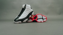 pair of black-and-white Air Jordan 13 shoes on gray surface