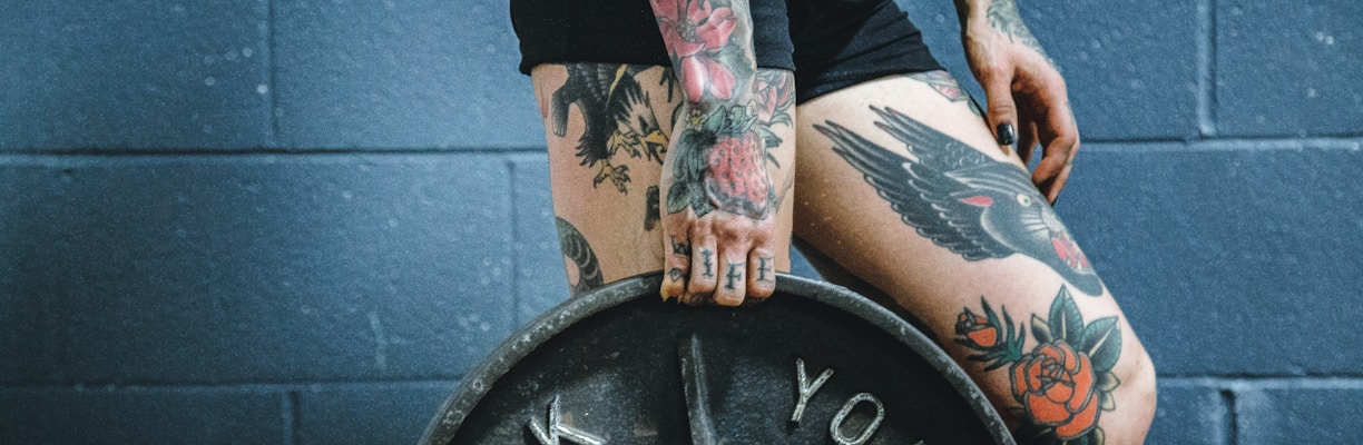 person carrying black weight plate with right hand