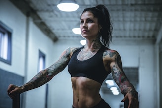 woman wearing black sports bra with tattoos