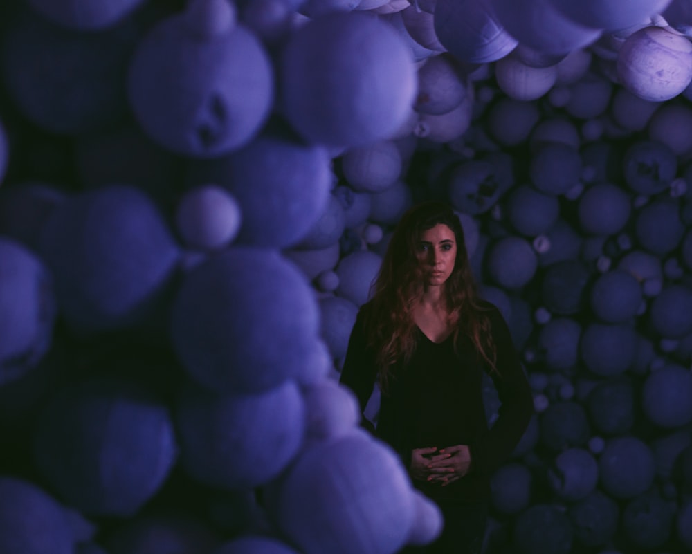 woman standing in the middle of piled balls