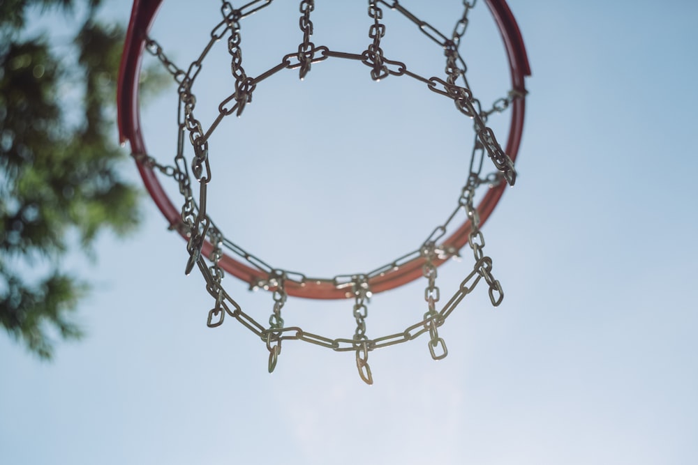 푸른 하늘 아래 빨간 농구 골대의 로우 앵글 사진