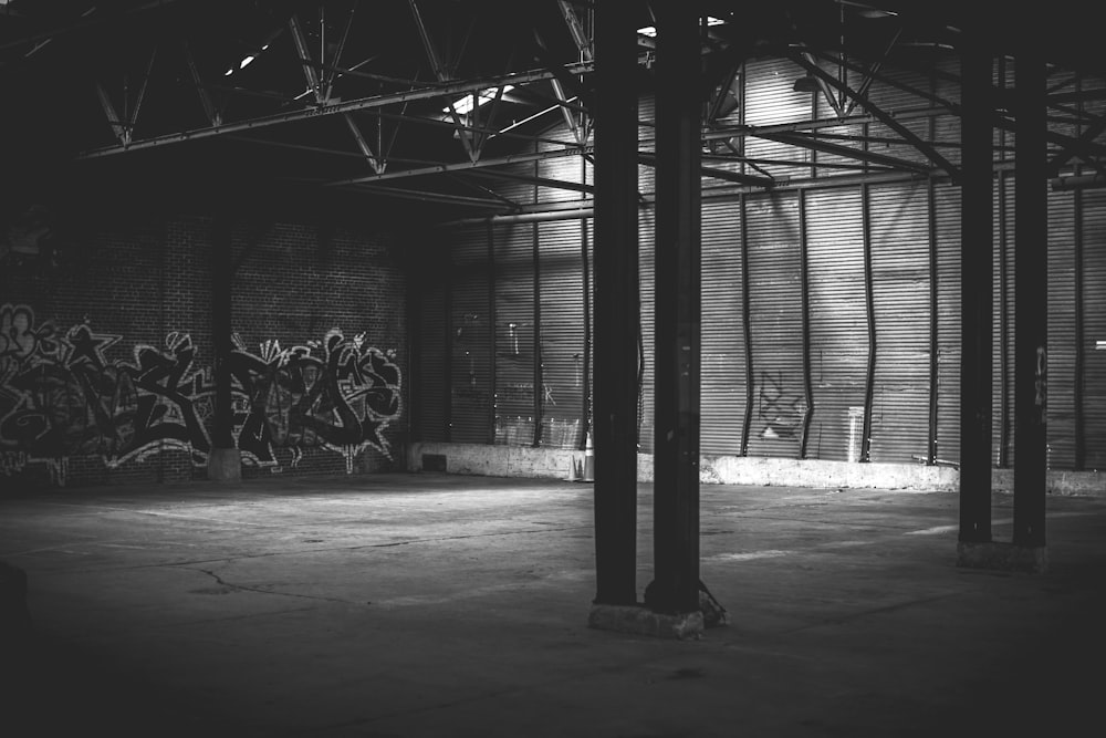 Foto in scala di grigi di un edificio con pareti dipinte con graffiti